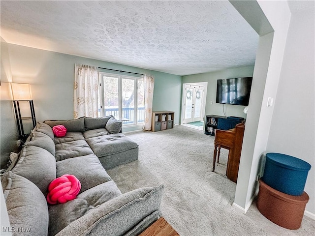 living room with carpet floors, baseboards, and a textured ceiling