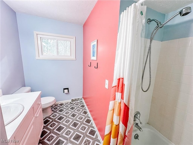 bathroom featuring a textured ceiling, vanity, shower / bath combo with shower curtain, and toilet