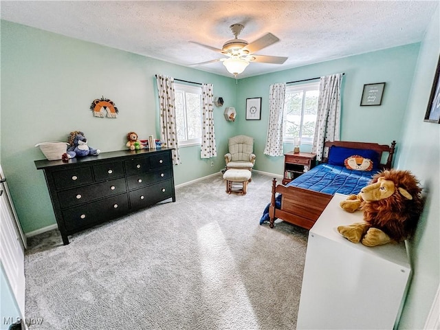 carpeted bedroom featuring a textured ceiling, a ceiling fan, and baseboards