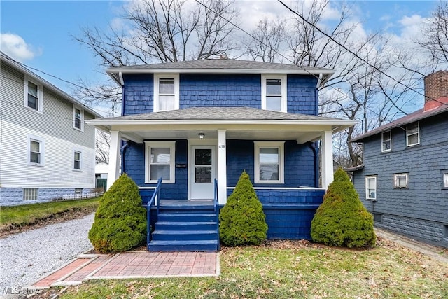 traditional style home with a porch and roof with shingles