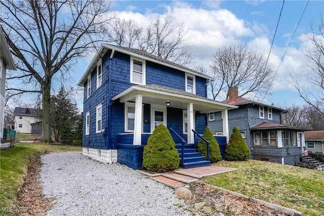 traditional style home featuring covered porch, driveway, and a chimney