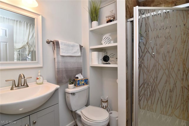 bathroom featuring vanity, a shower stall, and toilet