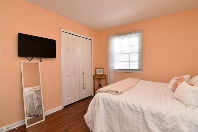 bedroom featuring a closet, dark wood finished floors, and baseboards