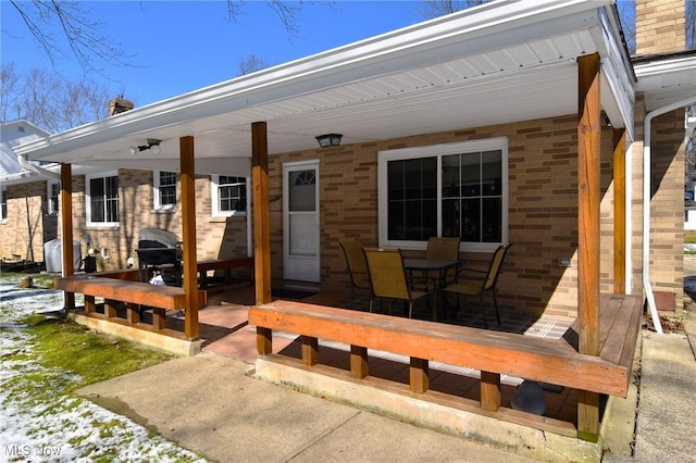 exterior space featuring brick siding and a chimney