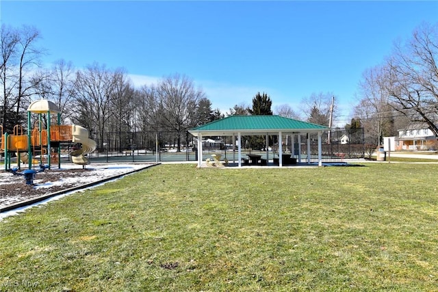 view of community featuring playground community, fence, a lawn, and a gazebo