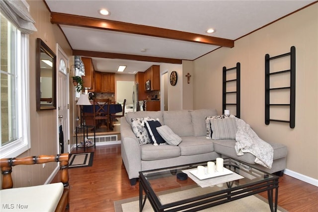 living area with beamed ceiling, plenty of natural light, wood finished floors, and baseboards