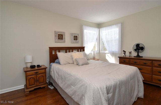 bedroom with dark wood finished floors and baseboards