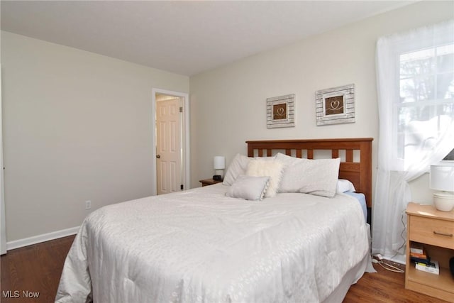 bedroom with dark wood-style flooring and baseboards