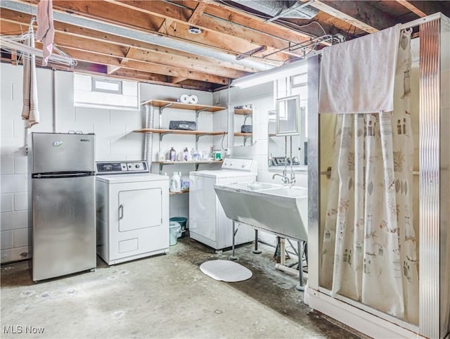 clothes washing area with laundry area, a sink, and washer and clothes dryer