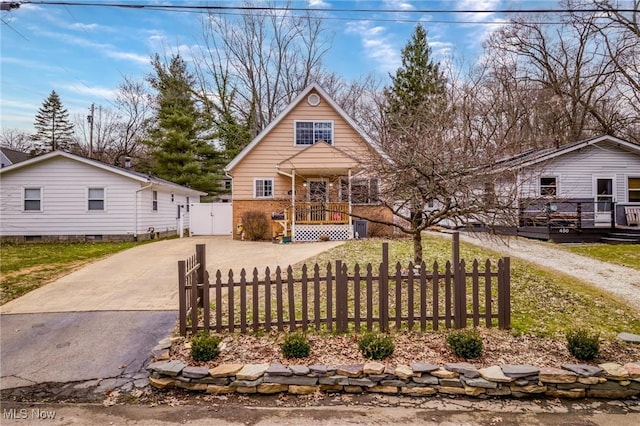 view of front of home featuring a fenced front yard, a gate, driveway, and a porch