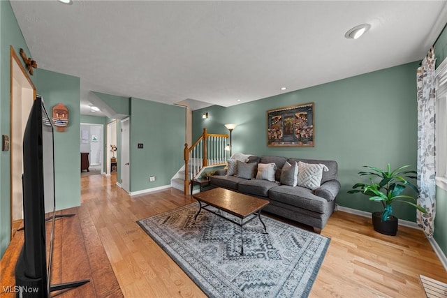 living room featuring stairway, wood finished floors, and baseboards