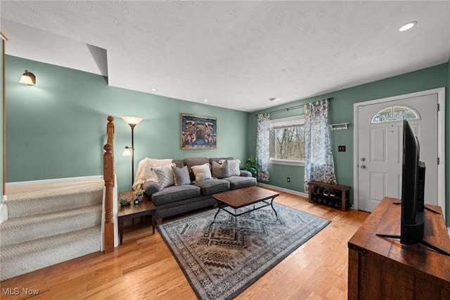 living room with light wood-style floors, recessed lighting, a textured ceiling, and baseboards