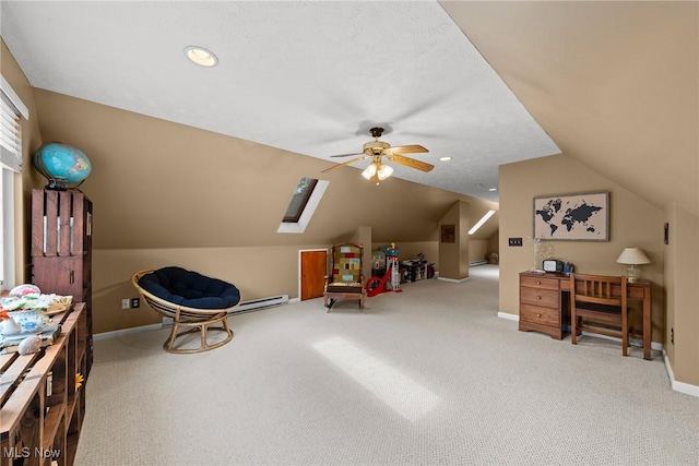 interior space with vaulted ceiling with skylight, carpet flooring, a ceiling fan, and baseboards