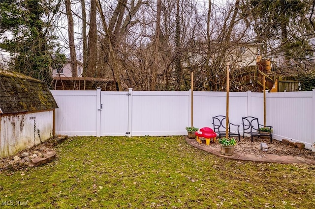 view of yard featuring a fenced backyard and a gate