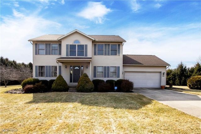 colonial house with an attached garage, a front lawn, and concrete driveway