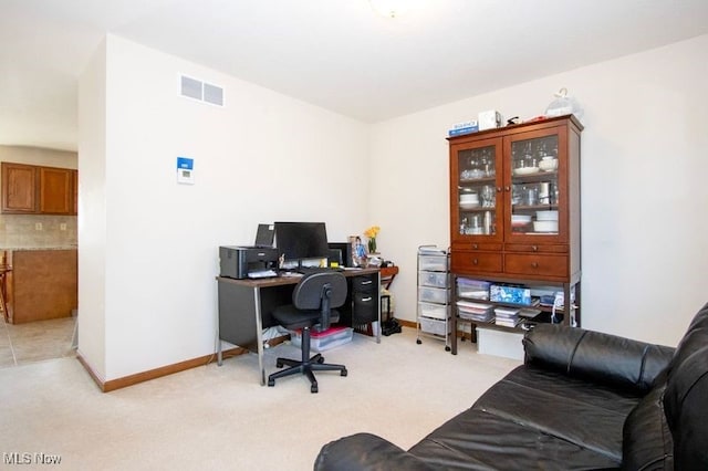 office space with light colored carpet, visible vents, and baseboards