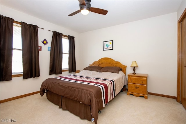 bedroom with baseboards, ceiling fan, and light colored carpet