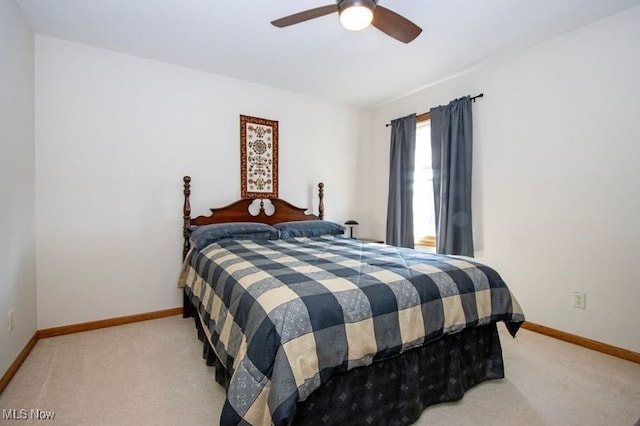 carpeted bedroom with ceiling fan and baseboards