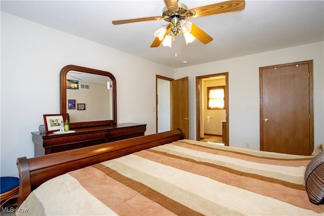 bedroom with ensuite bathroom, visible vents, and a ceiling fan