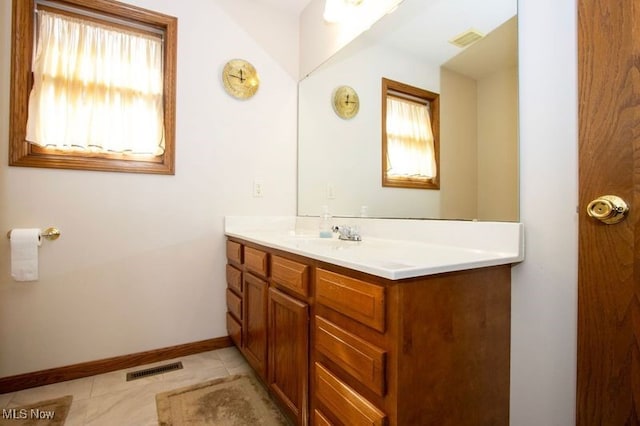 bathroom featuring tile patterned flooring, vanity, visible vents, and baseboards