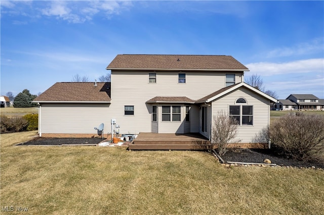 rear view of property with a lawn and a wooden deck