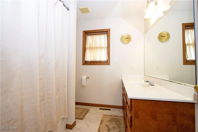 full bath with vanity, visible vents, and baseboards