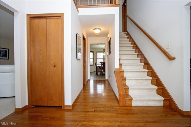 foyer featuring stairway, wood finished floors, and baseboards