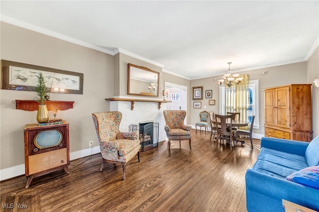 living area featuring a fireplace, wood finished floors, baseboards, ornamental molding, and an inviting chandelier