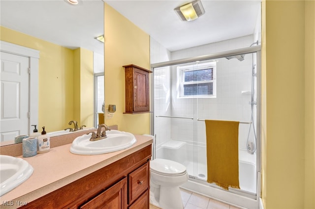 full bath featuring double vanity, toilet, tile patterned flooring, a shower stall, and a sink