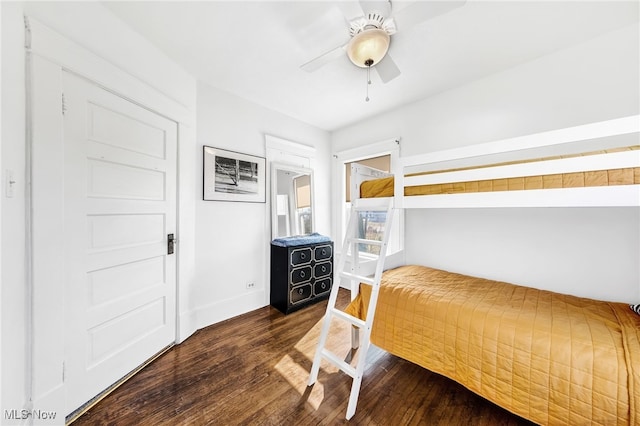 bedroom featuring dark wood-style floors, a ceiling fan, and baseboards