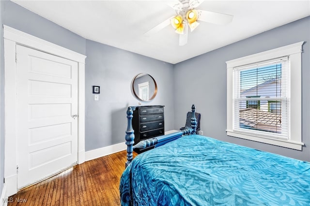 bedroom with a ceiling fan, baseboards, and wood finished floors