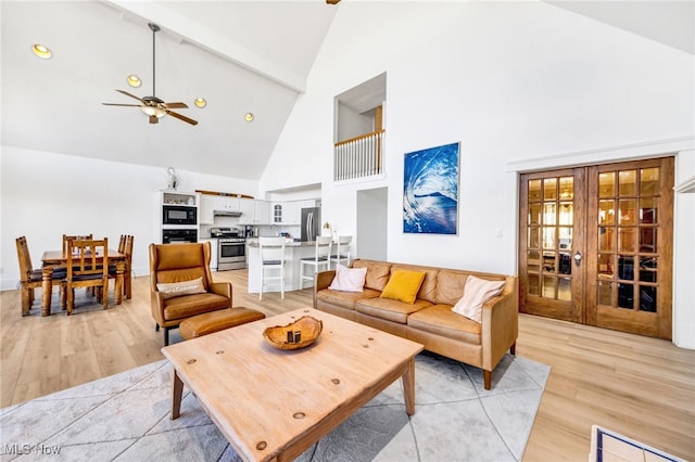 living room with light wood-style floors, french doors, high vaulted ceiling, and a ceiling fan