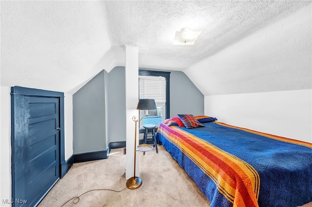 bedroom with a textured ceiling, baseboards, vaulted ceiling, and carpet flooring