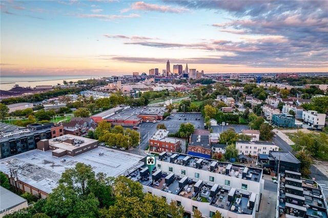 aerial view at dusk featuring a water view and a city view