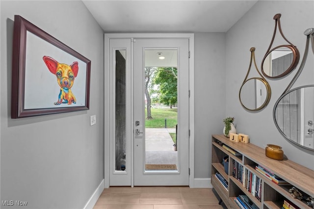 entrance foyer with light tile patterned floors and baseboards