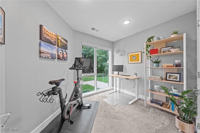 workout area featuring baseboards, visible vents, and carpet flooring