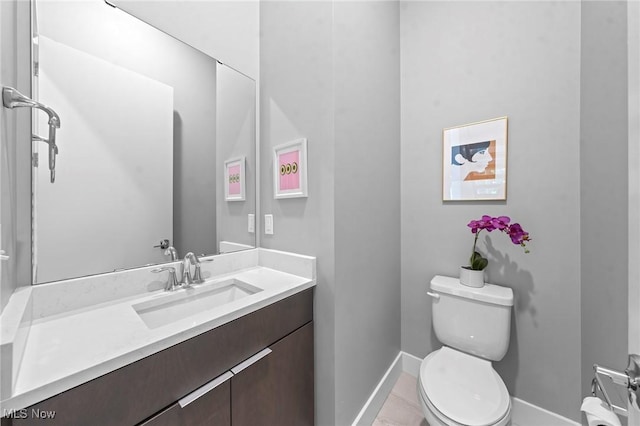 bathroom featuring toilet, tile patterned flooring, baseboards, and vanity