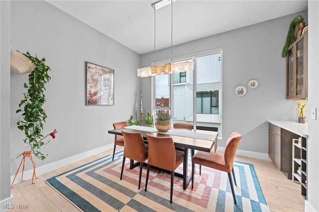 dining area featuring light wood-style flooring and baseboards