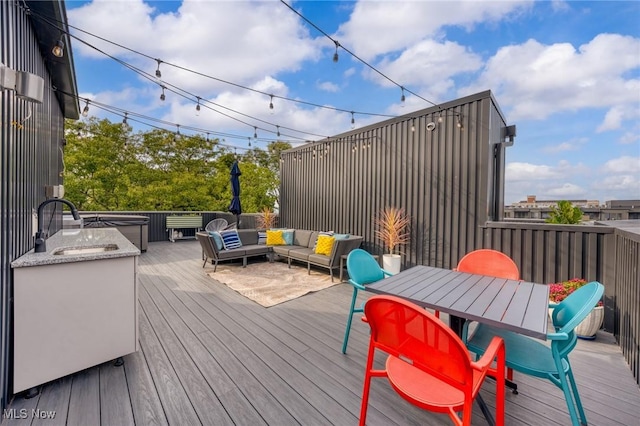 wooden deck featuring outdoor dining space, outdoor lounge area, and a sink