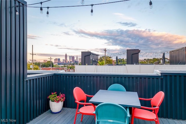 wooden terrace featuring a view of city and outdoor dining space