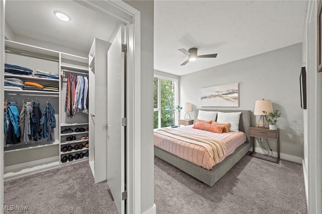 carpeted bedroom featuring a closet, baseboards, and a ceiling fan