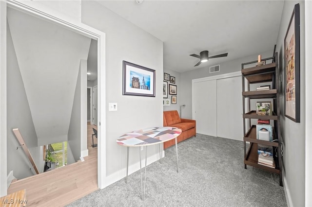 interior space with visible vents, carpet flooring, ceiling fan, an upstairs landing, and baseboards