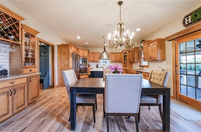 dining space with light wood-type flooring, an inviting chandelier, and recessed lighting