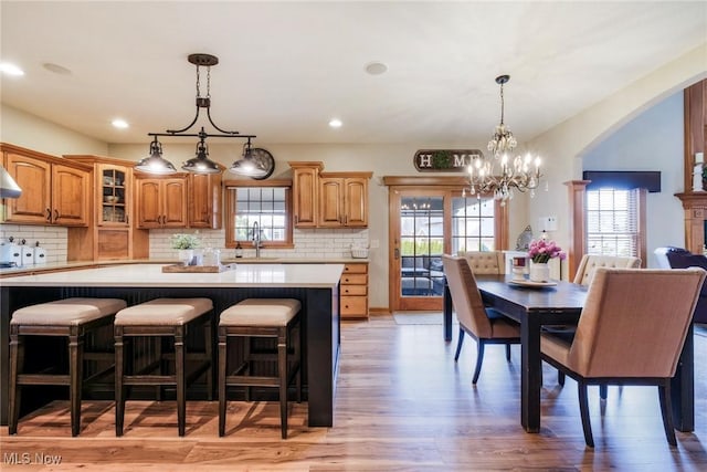 kitchen with glass insert cabinets, plenty of natural light, light countertops, and a kitchen island