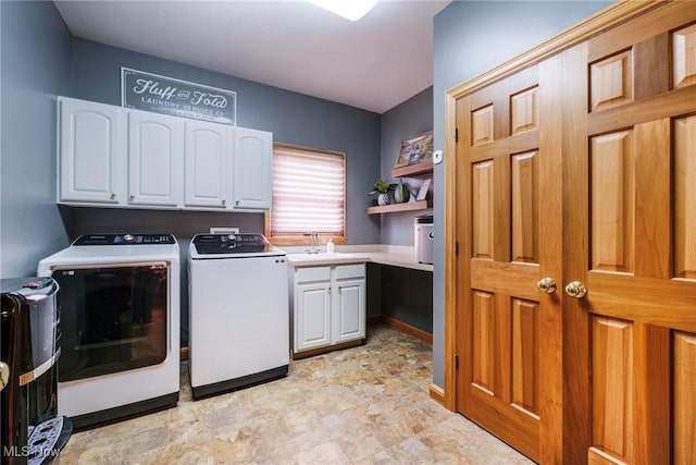 clothes washing area with cabinet space, a sink, and washer and clothes dryer