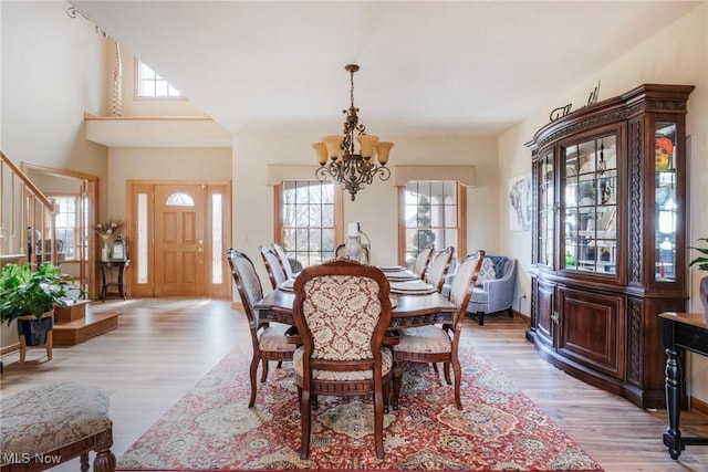 dining room with baseboards, light wood-type flooring, and an inviting chandelier