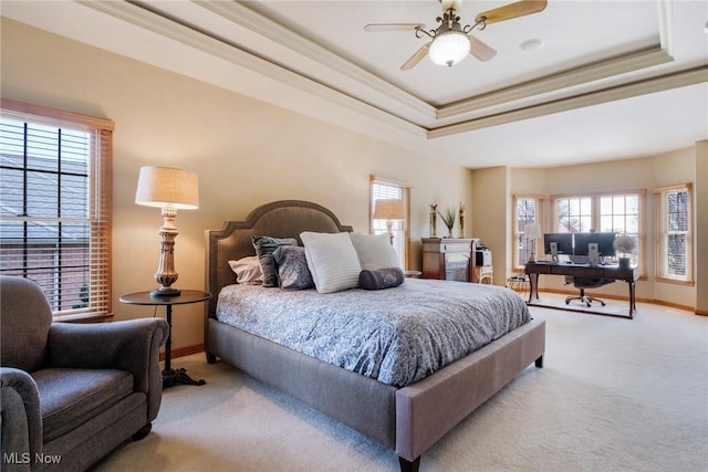 bedroom featuring baseboards, ornamental molding, a raised ceiling, and light colored carpet