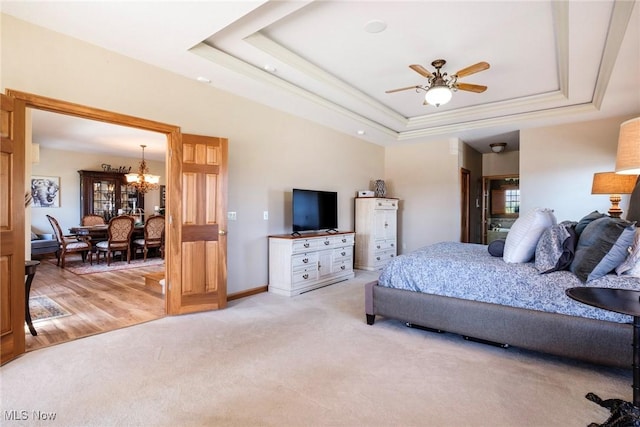 bedroom featuring baseboards, a tray ceiling, light colored carpet, and a notable chandelier