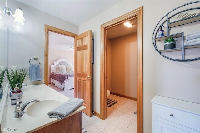 full bath featuring double vanity, connected bathroom, toilet, tile patterned floors, and a sink