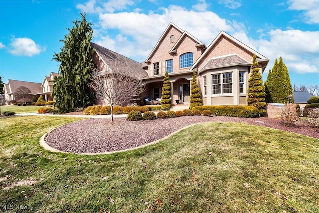 view of front of home with brick siding and a front lawn